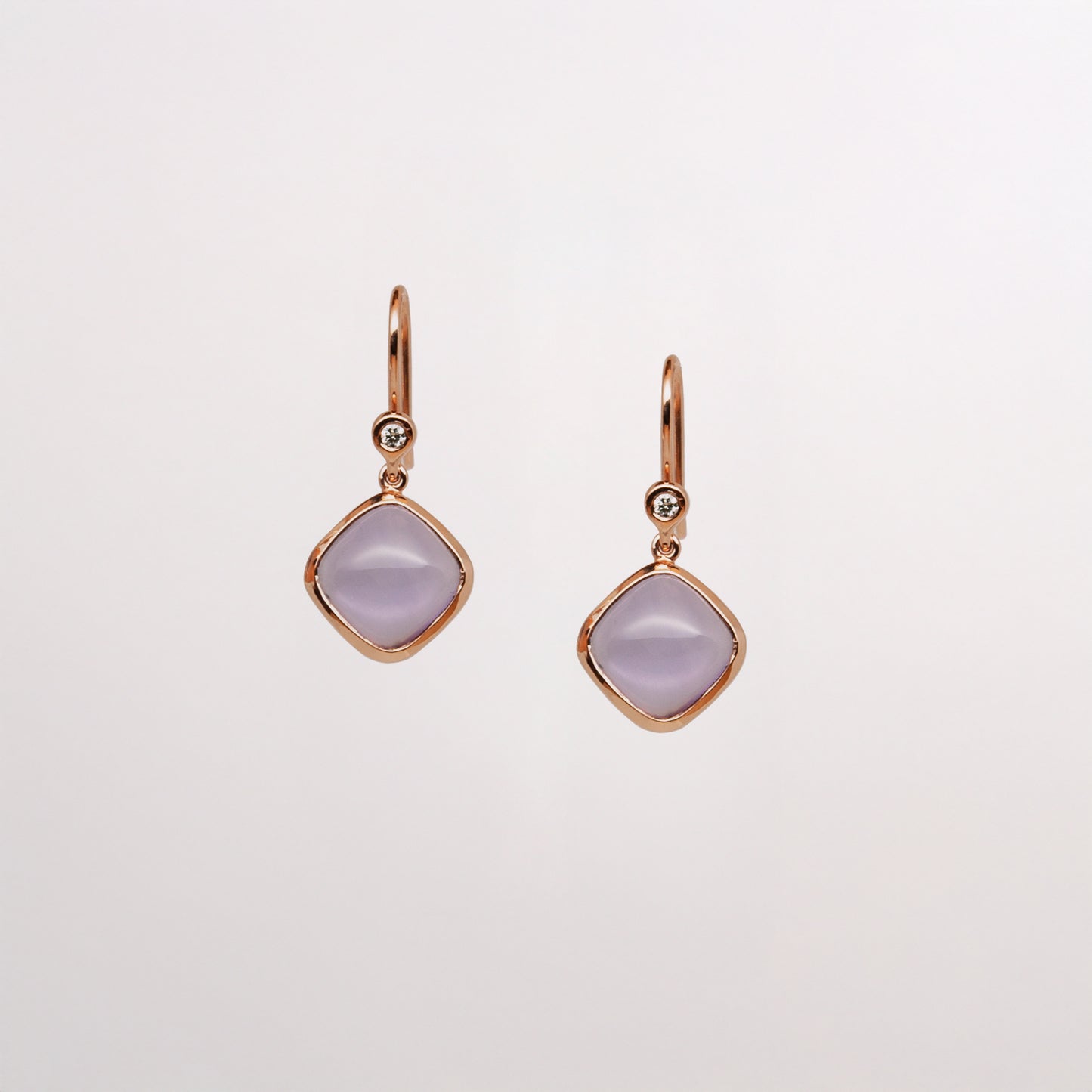 A pair of square amethyst gold earrings in rose gold with diamond accents, hanging from ear hooks.