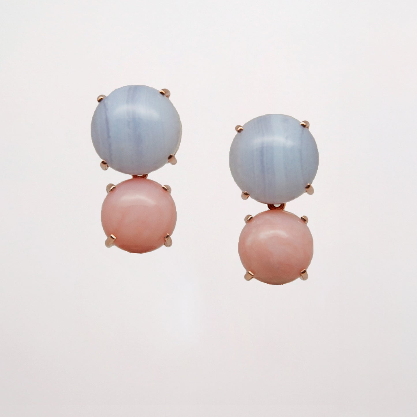 Chalcedony and Pink Opal as a pair of pink and blue gemstone earrings on white background set in rose gold