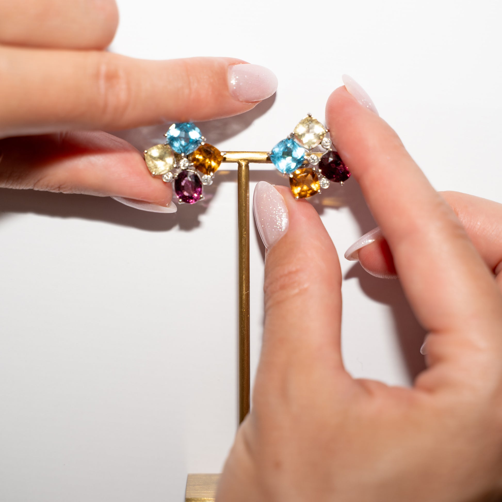 Colorful Stud Earrings Gold and hands for size reference 