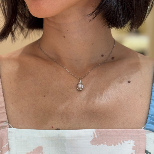 Moonstone Gold Pendant, made of white gold, designed in Switzerland and worn by a model.